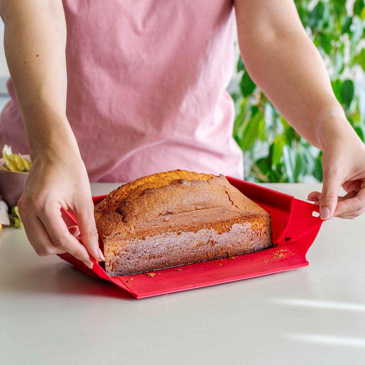 Silikonisesta leipävuuasta irroitetaan kakku helposti vaalean keittiötason päällä.