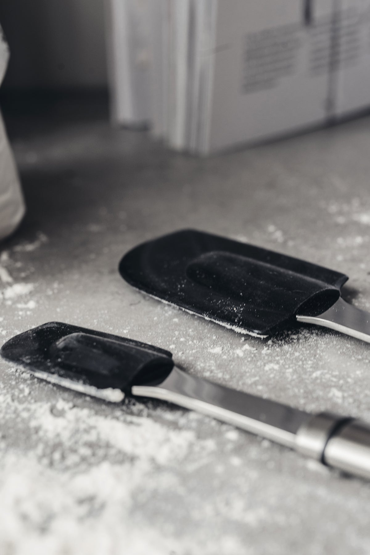 Teräksinen silikoninuolija keittiön tasolla pienen nuolijan vieressä.